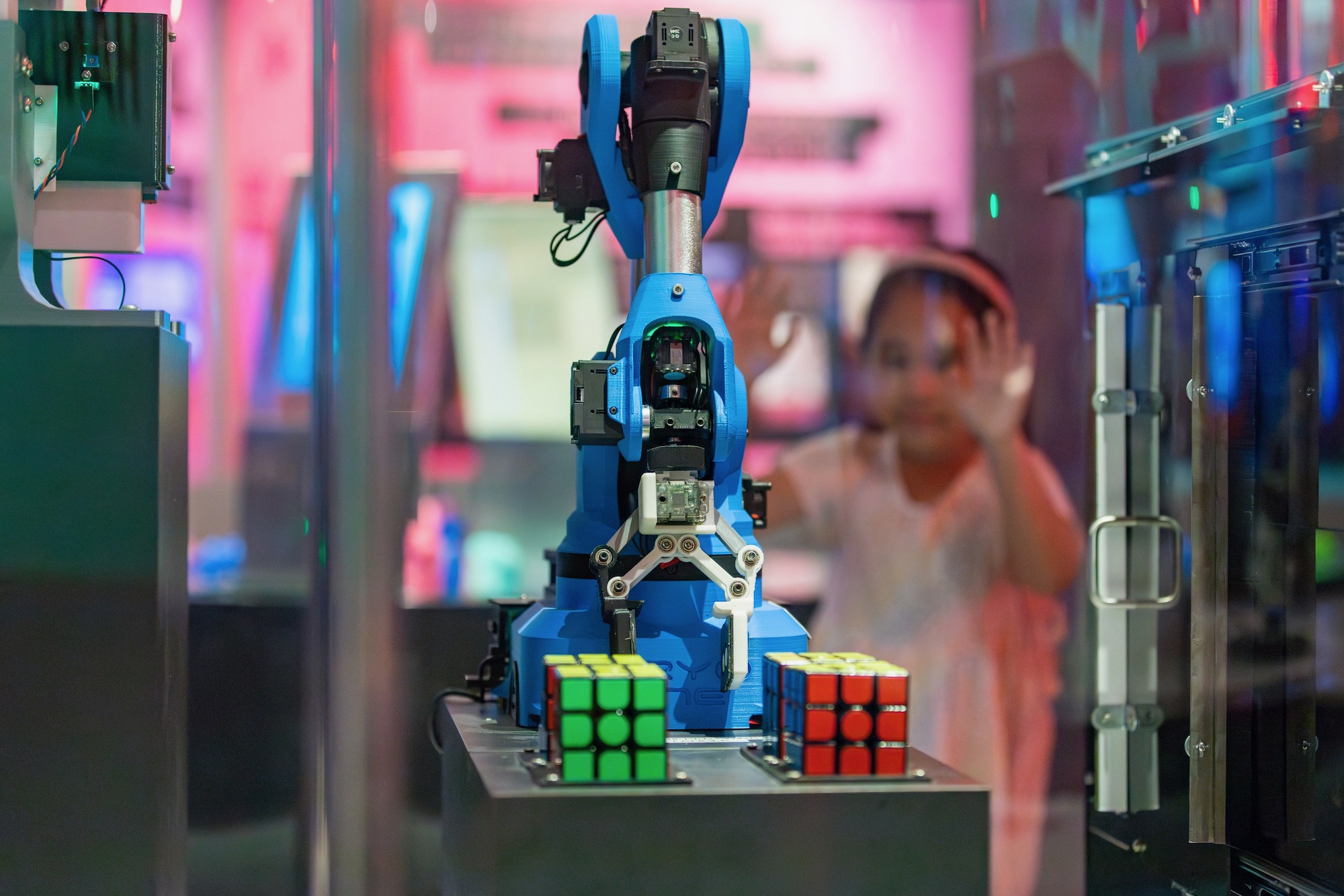 Robot with 2 Rubik's Cubes in an enclosed glass case